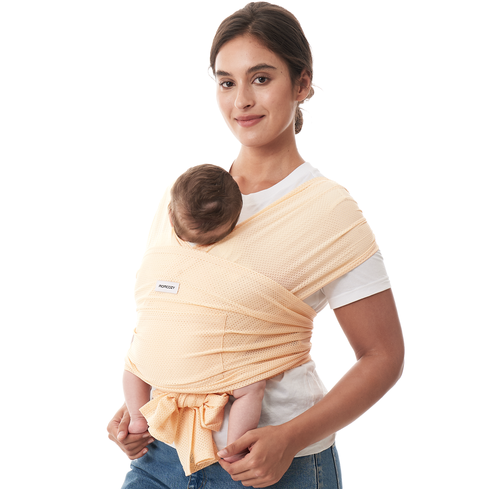 Momcozy baby wrap carrier in peach color, hands-free design for comfortable babywearing. 'Momcozy' logo visible.