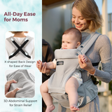 Light gray Momcozy Move2Fit Hip Seat Carrier in use; ergonomic design for baby and mom, X-shaped back and 3D support.