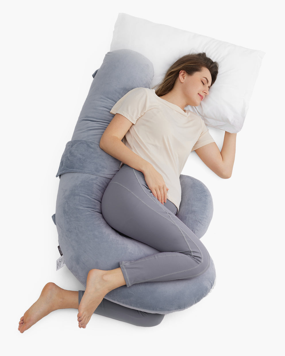 Pregnant woman side-sleeping on a gray F-shaped pregnancy pillow for comfort and support during pregnancy.