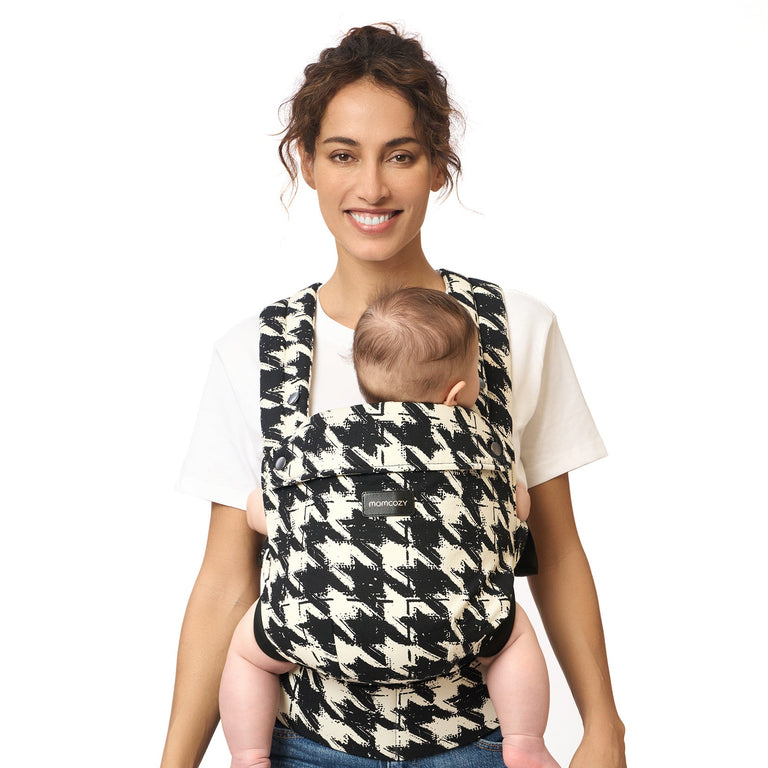 Translation missing: en.Momcozy PureHug baby carrier, houndstooth design. Mother babywearing a newborn, comfortable and supportive