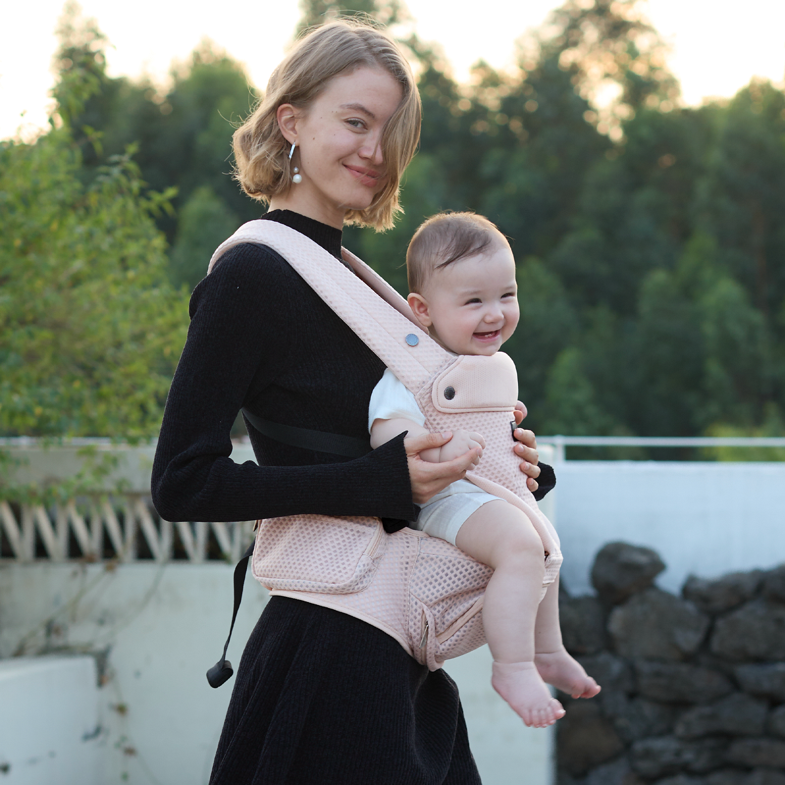 Momcozy Move2Fit Hip Seat Carrier in blush pink, mother and baby smiling, ergonomic design for comfort