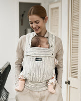 Momcozy PureHug baby carrier in striped design. Mother babywearing with newborn, comfortable and stylish.