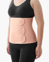 Momcozy Ergowrap Postpartum Belly Band in oyster pink color worn by a woman, with adjustable straps for postpartum support.