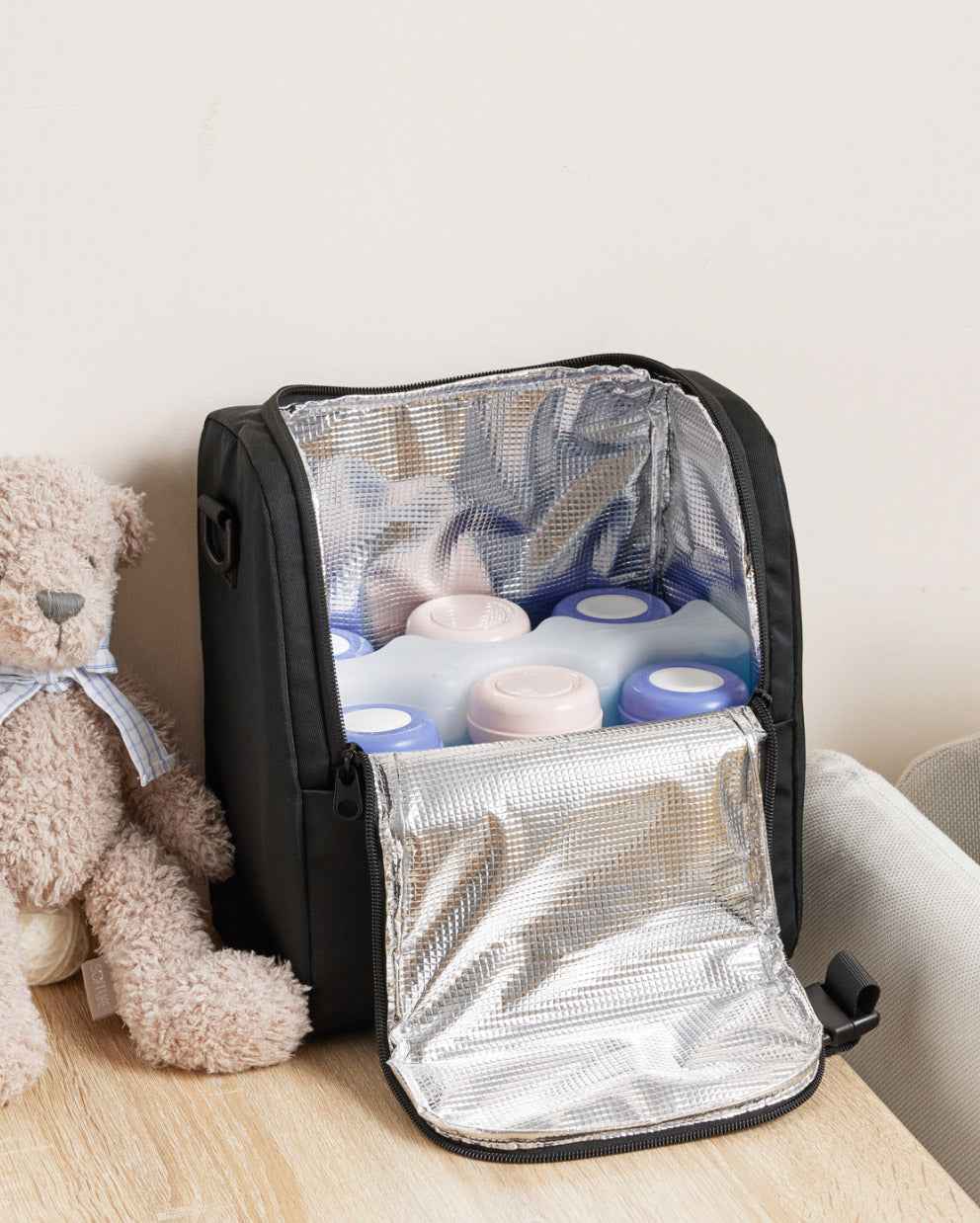 Momcozy black insulated baby bottle bag, open to display bottles inside; portable and convenient for mom care.
