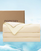 Soft beige Momcozy cooling comforter with packaging in tranquil blue atmosphere.