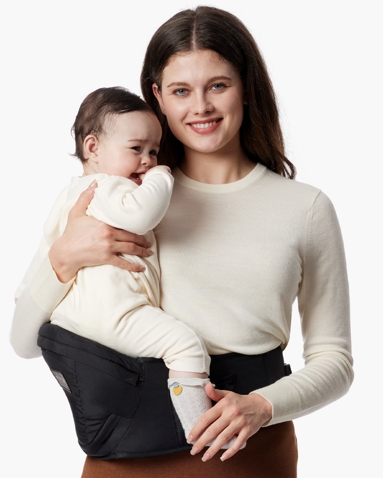Translation missing: en.Momcozy Wander360 Hip Seat Carrier: Woman holding baby in a black carrier, babywearing solution for comfort and convenience