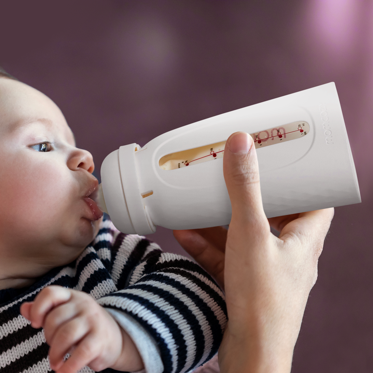 Baby feeding with Momcozy bottle designed for direct-feeding with easy-to-read measurement.