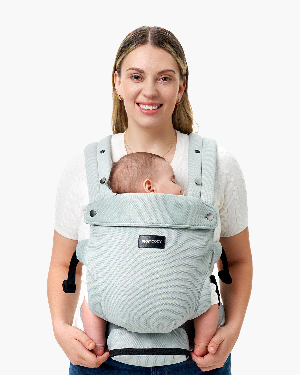 Momcozy baby carrier in light blue, supporting a sleeping baby, worn by a smiling parent, featuring the Momcozy logo.